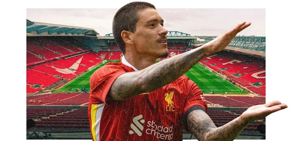 Player gesturing in front of Anfield stadium