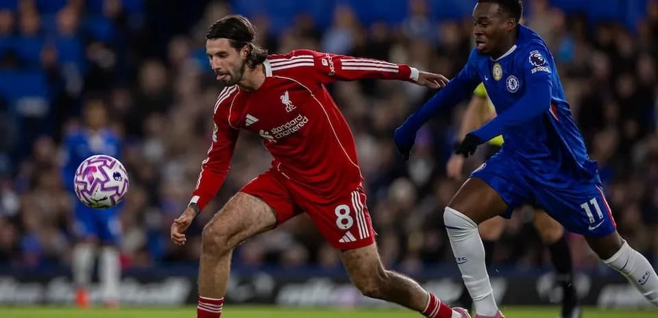 Liverpool player challenging Chelsea opponent for the ball