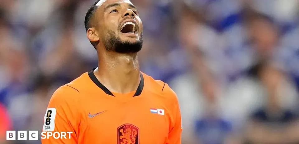 Player in orange jersey looking up on the pitch