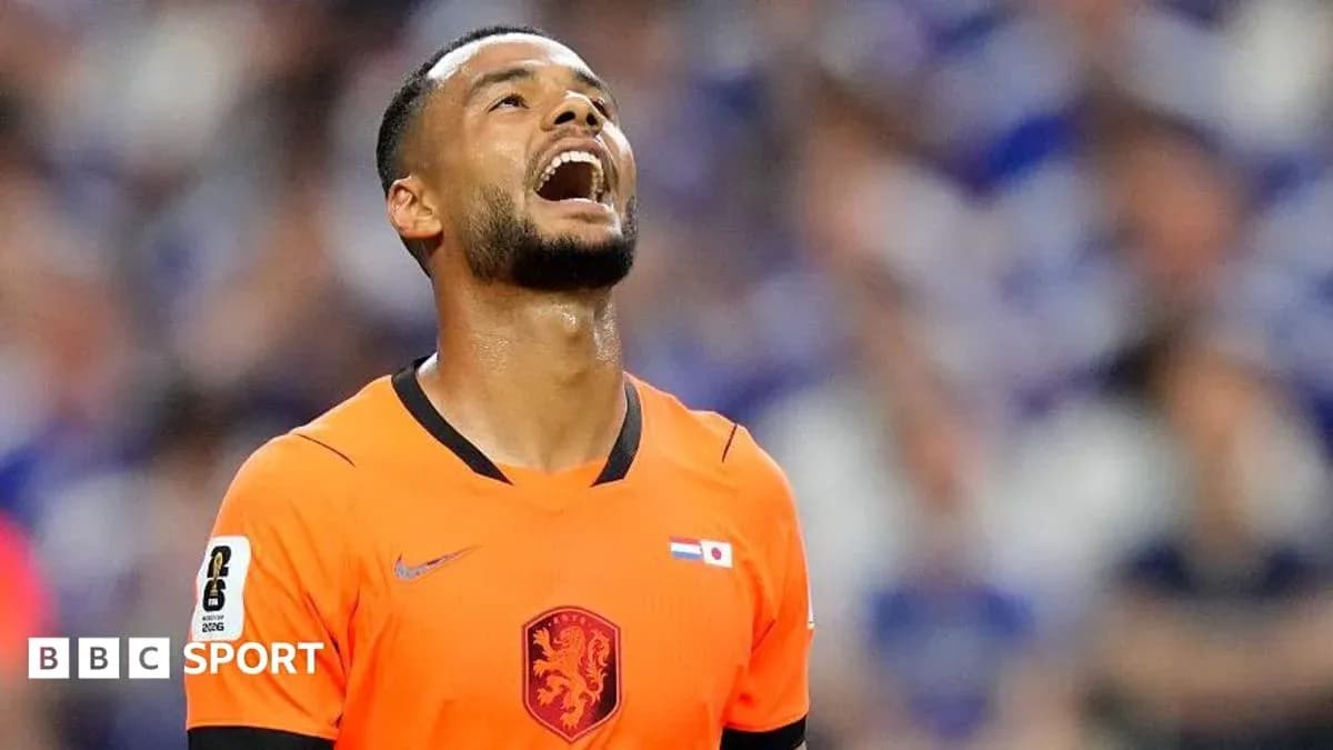 Player in orange jersey looking up on the pitch
