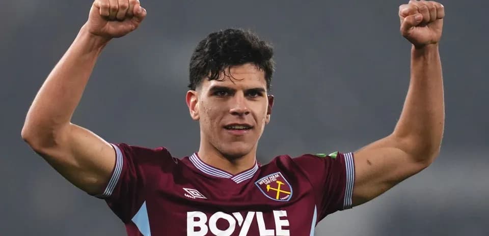 Player celebrating with raised fists in team jersey