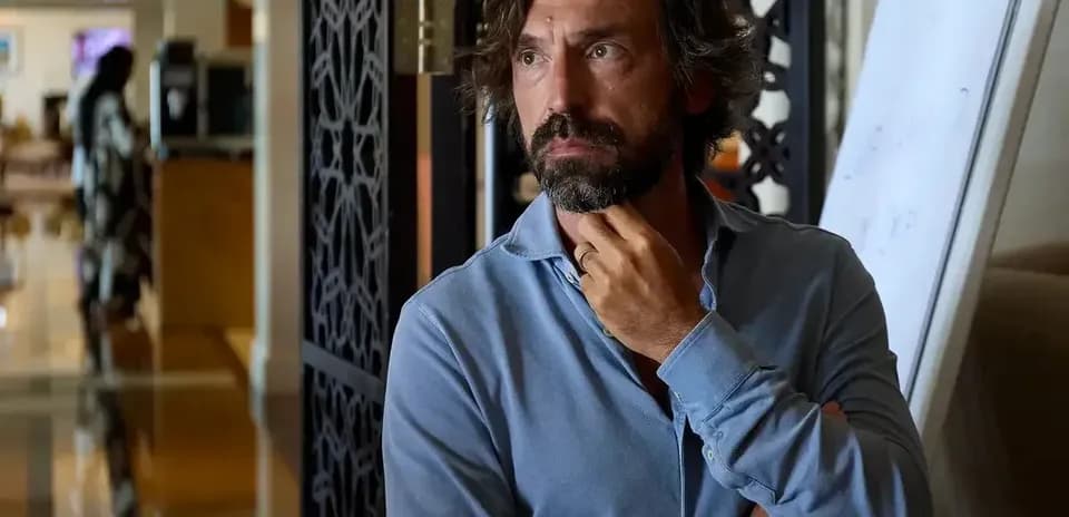 Man in blue shirt with thoughtful expression indoors
