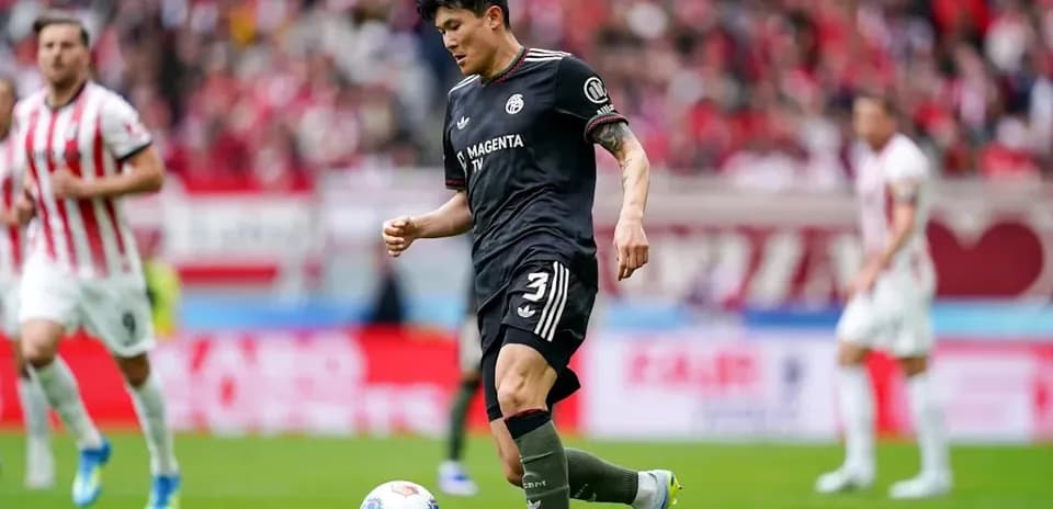 Player in black kit preparing to kick the ball