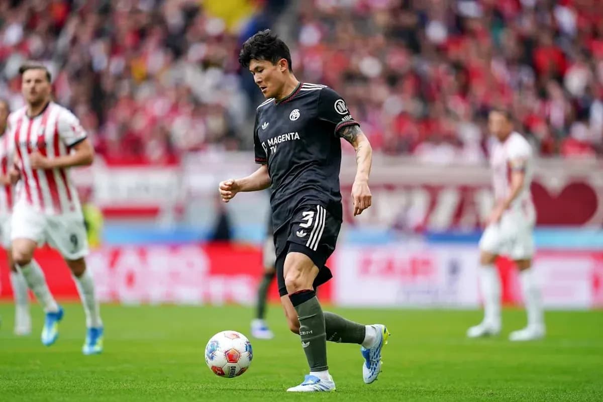 Player in black kit preparing to kick the ball