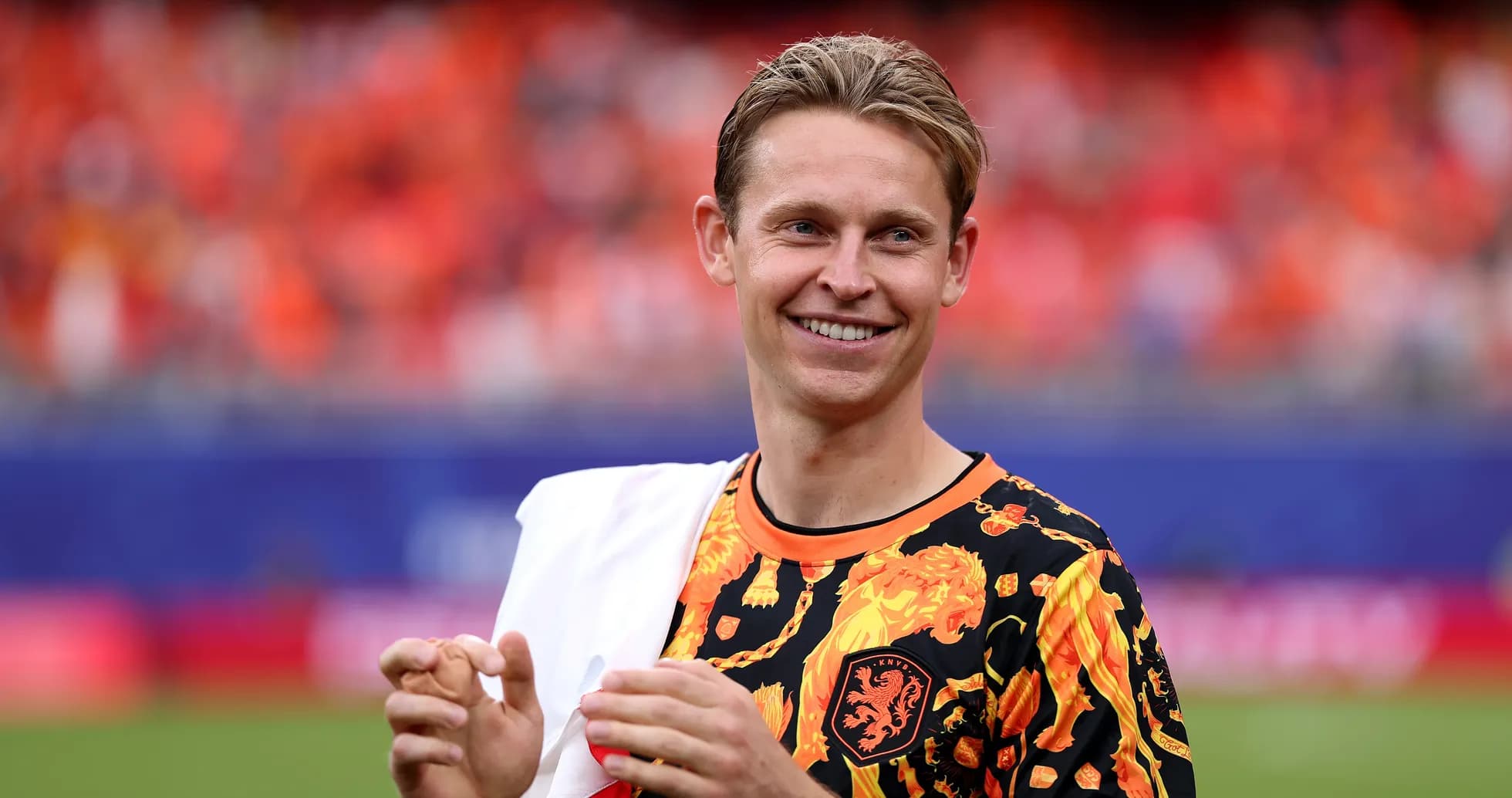 Player smiling in vibrant team jersey on field