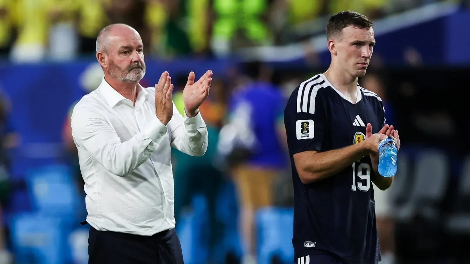 Manager and player applauding after the match