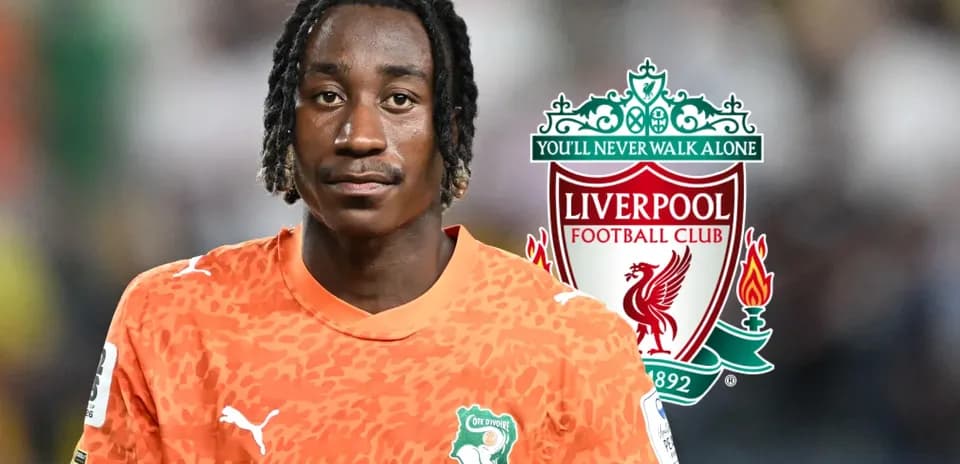 Player in orange jersey with Liverpool logo background