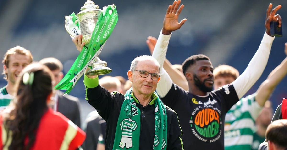 Man holding trophy with green ribbons, celebrating