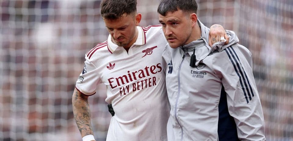 Player receiving assistance from medical staff on pitch
