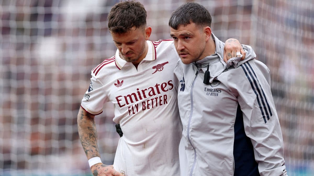 Player receiving assistance from medical staff on pitch