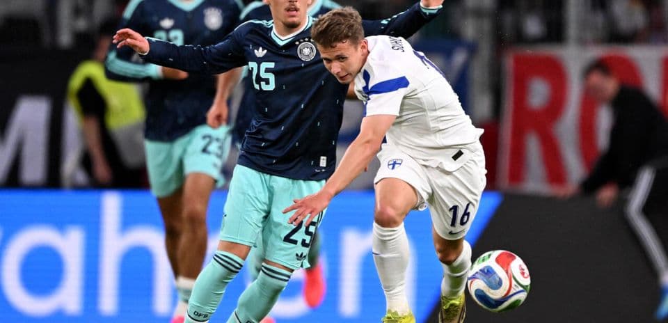 German player tackling Finnish player during match