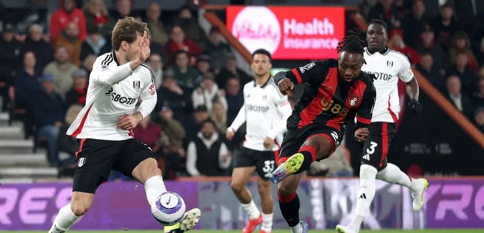 Fulham player challenging Bournemouth opponent for the ball