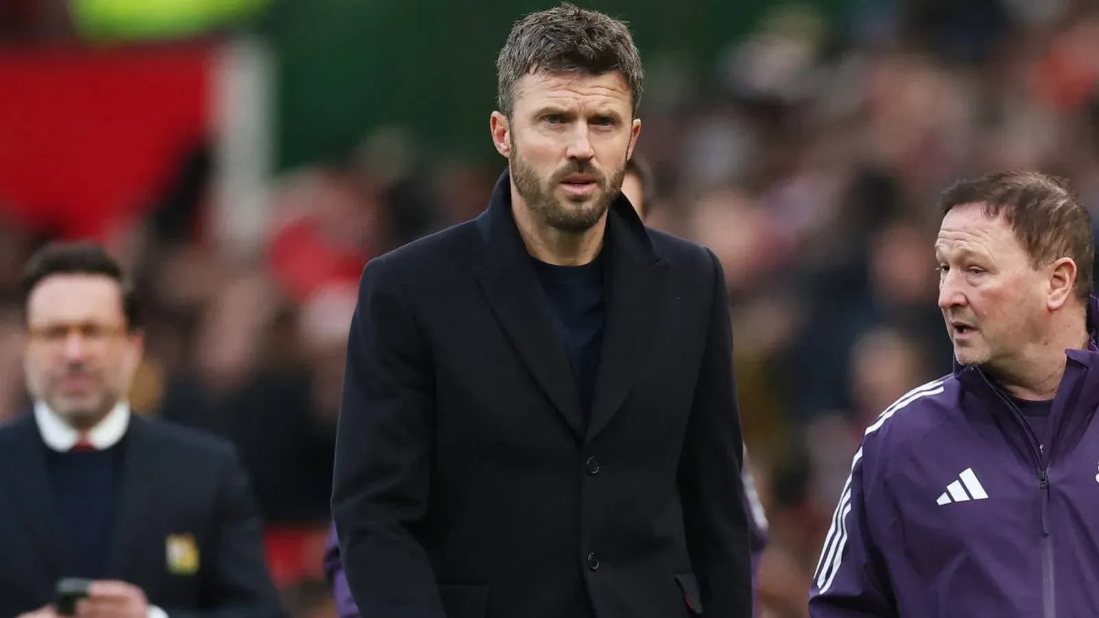 Coach walking alongside staff during match