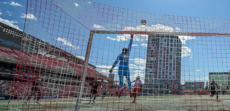 Goalkeeper reaching for the ball in match