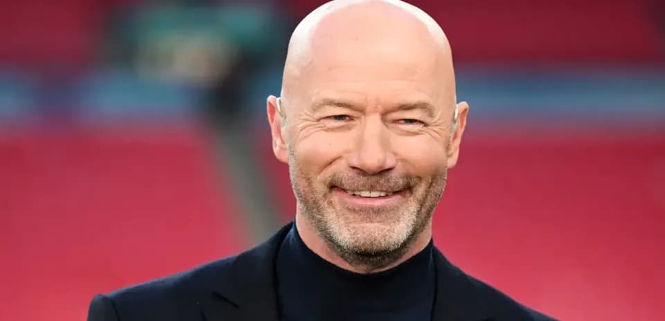 Bald man smiling in a sports venue