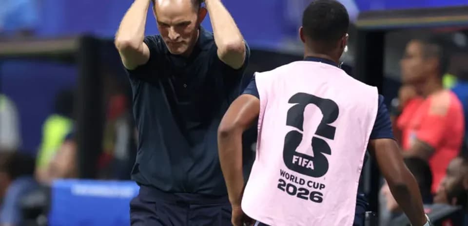 Coach reacting during match with staff member nearby