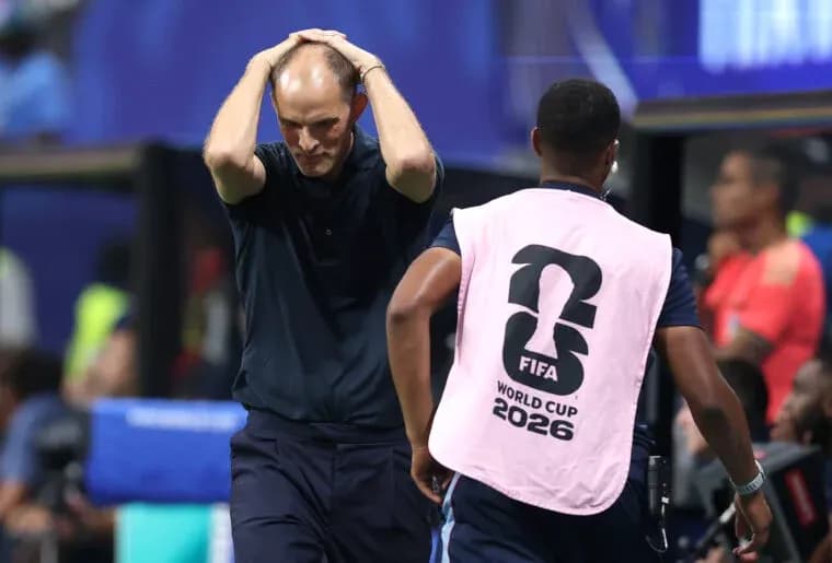 Coach reacting during match with staff member nearby