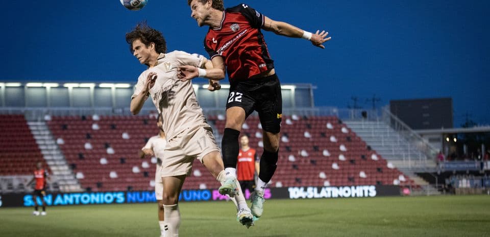 Players contesting a header during FC Tulsa match
