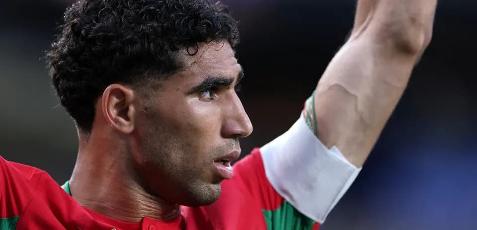 Player celebrating with arm raised in red jersey