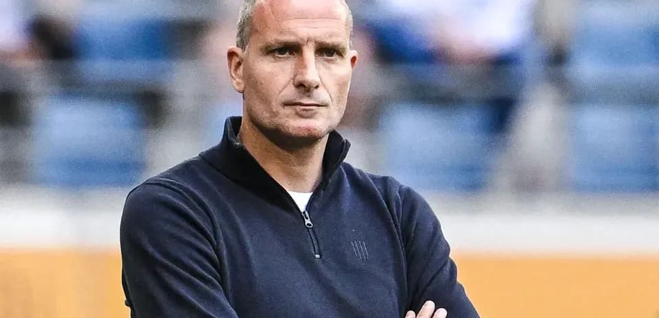 Coach observing match with arms crossed