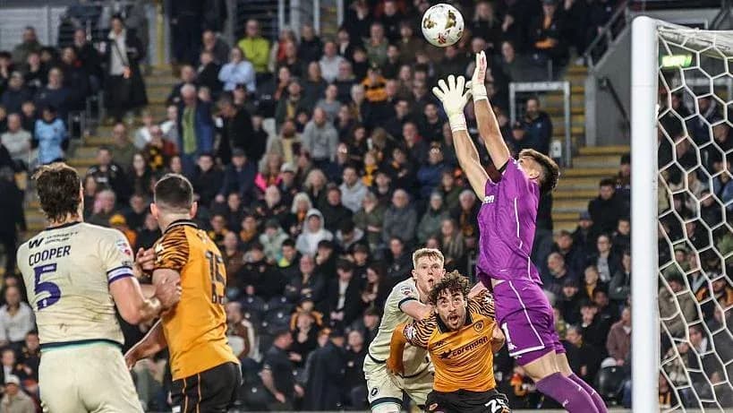 Goalkeeper jumping to catch ball during match