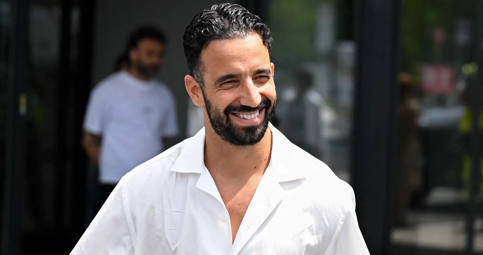 Smiling man in white shirt walking outdoors