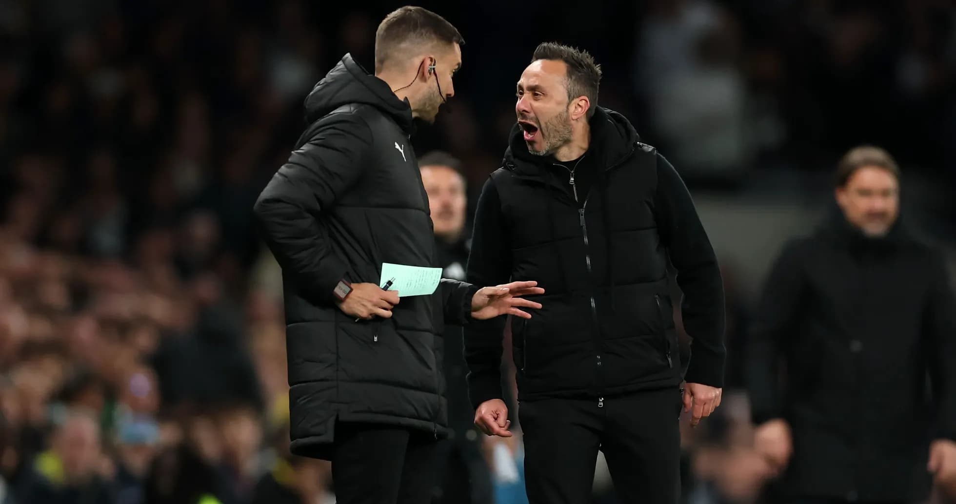 Two coaches discussing during a football match