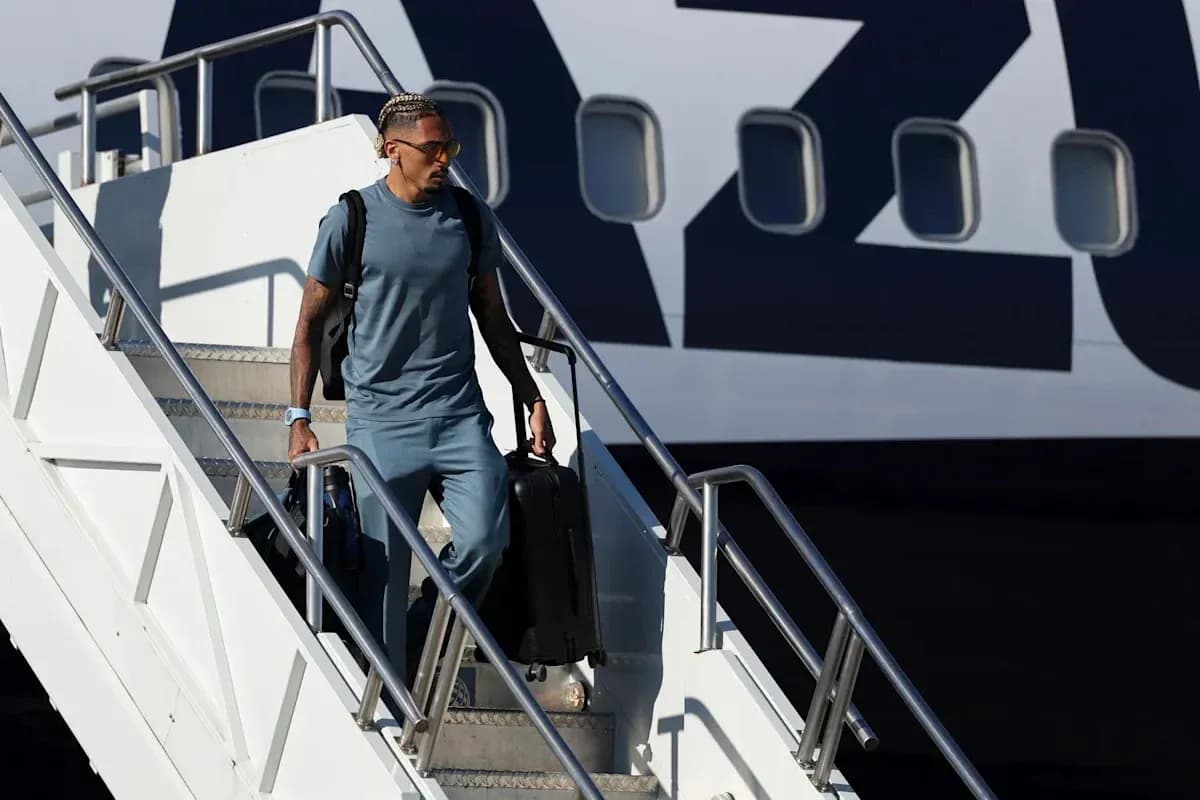 Player descending airplane steps with suitcase