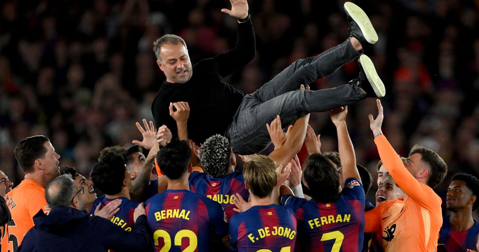Team celebrating by lifting their coach after victory