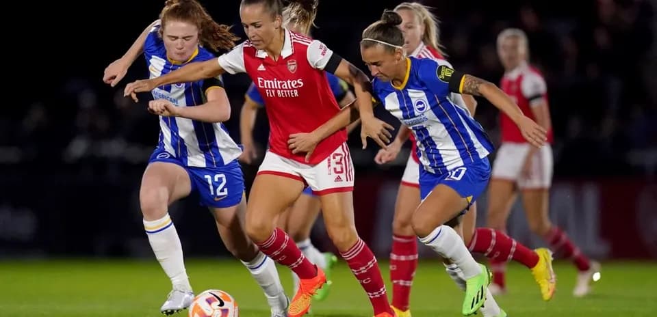 Brighton W players challenging Arsenal W for the ball