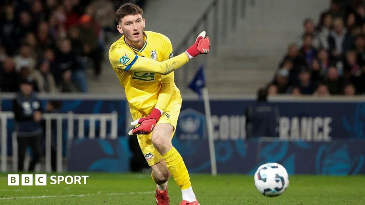 Goalkeeper in yellow kit preparing to kick ball