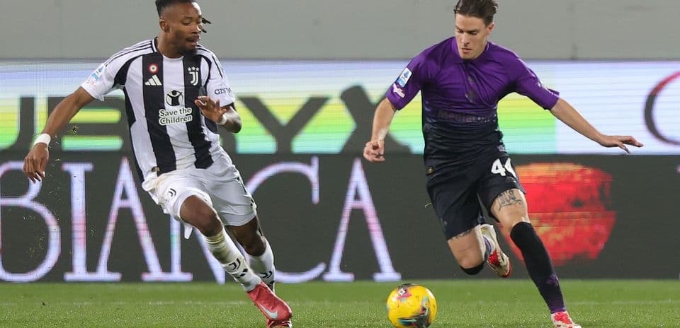 Juventus player challenging Fiorentina opponent for the ball