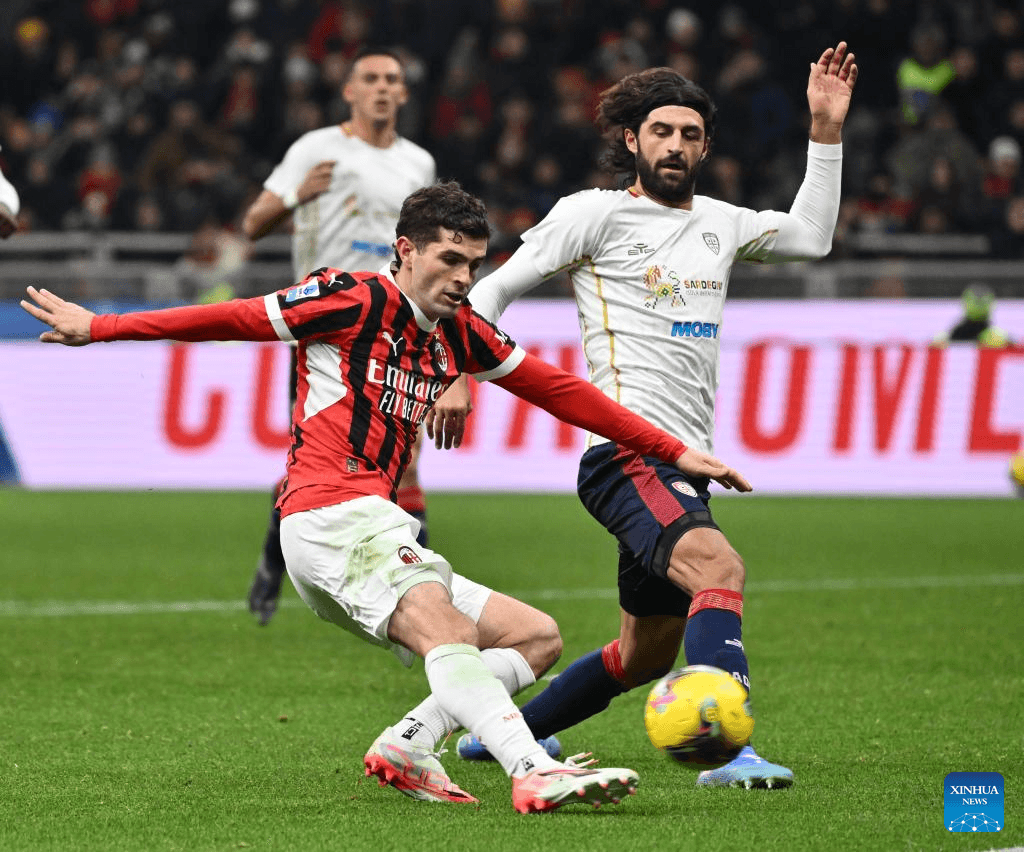 AC Milan player tackling Cagliari opponent during match