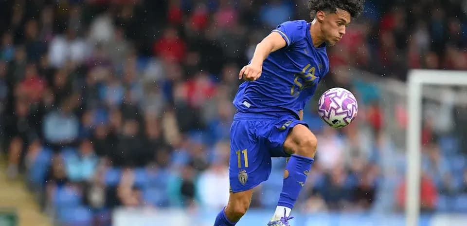 Player in blue jersey dribbling ball during match