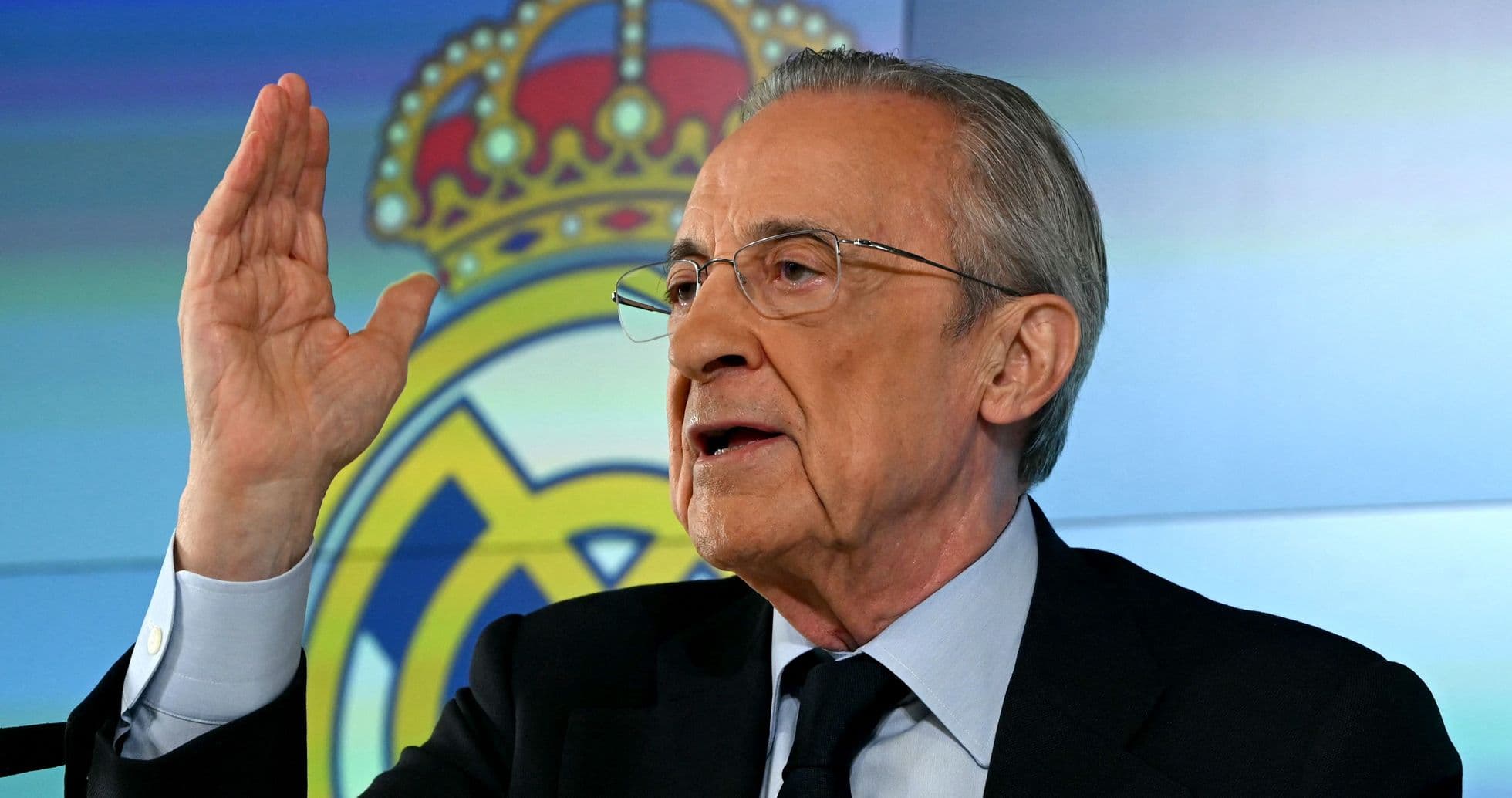 Official speaking at press conference with Real Madrid logo
