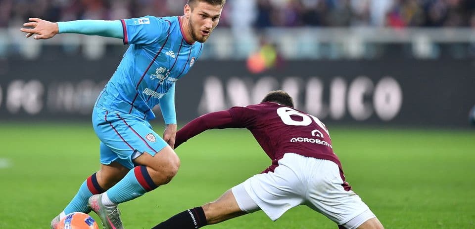 Cagliari player evading tackle during Serie A match