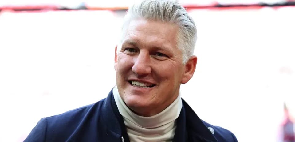 Smiling man in a navy jacket and turtleneck