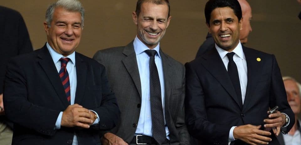 Three football executives smiling in a stadium box