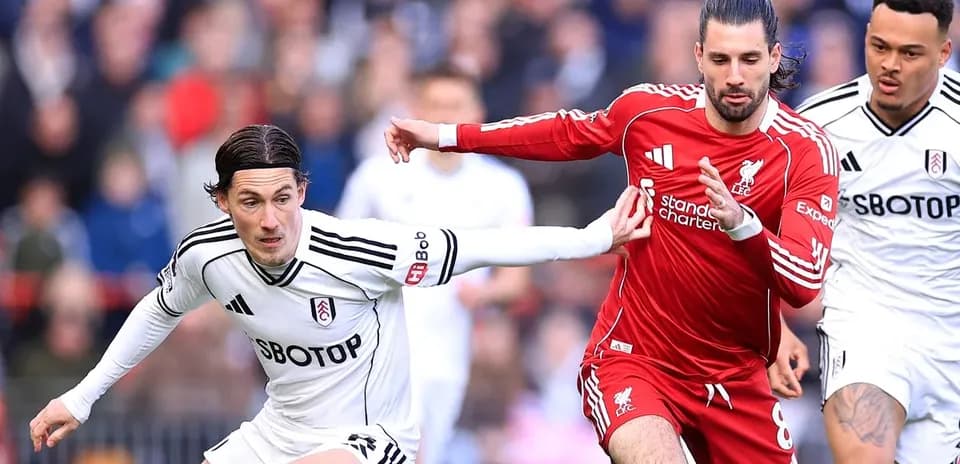 Fulham and Liverpool players competing for the ball
