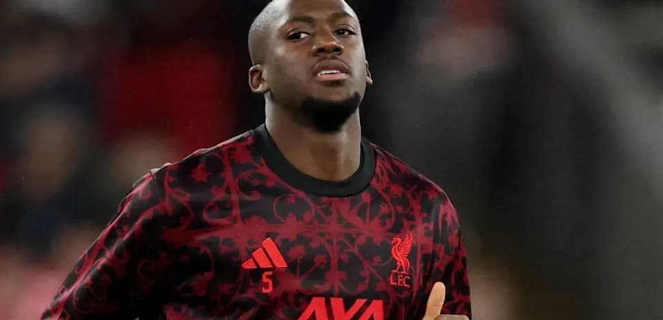 Player in Liverpool kit warming up on pitch