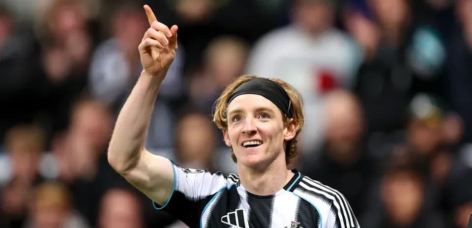 Player celebrating goal with raised finger in stadium