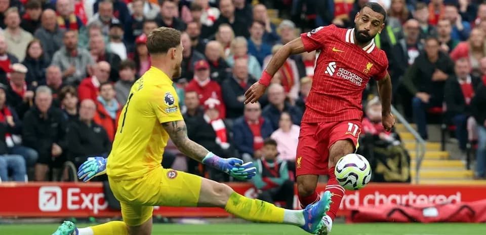 Liverpool player evading goalkeeper during match