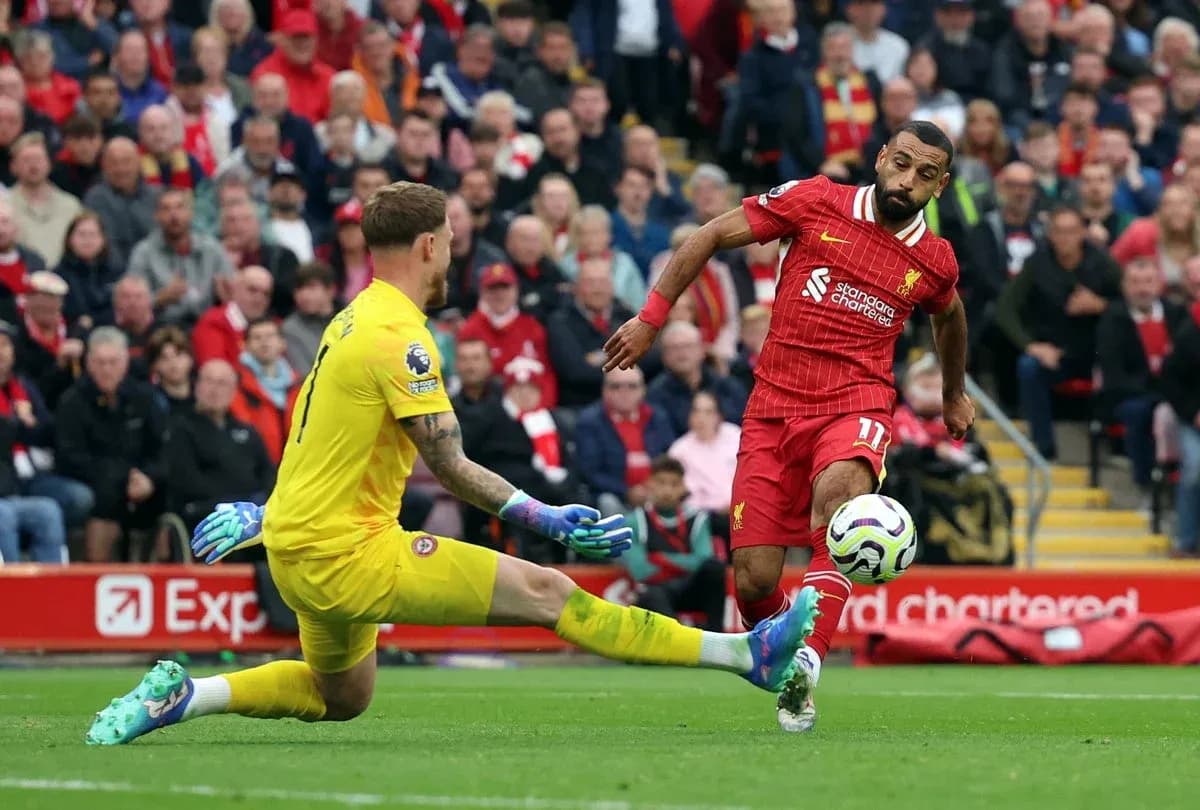 Liverpool player evading goalkeeper during match