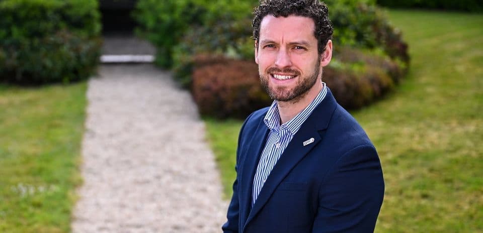 Man in a suit standing on a garden pathway