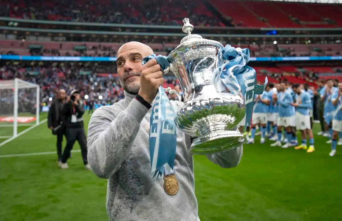 Manager holding trophy with team celebrating in background
