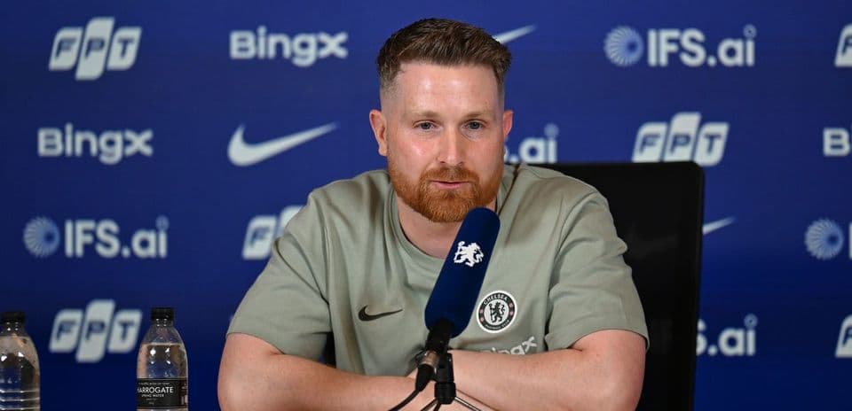 Manager at press conference with branded backdrop