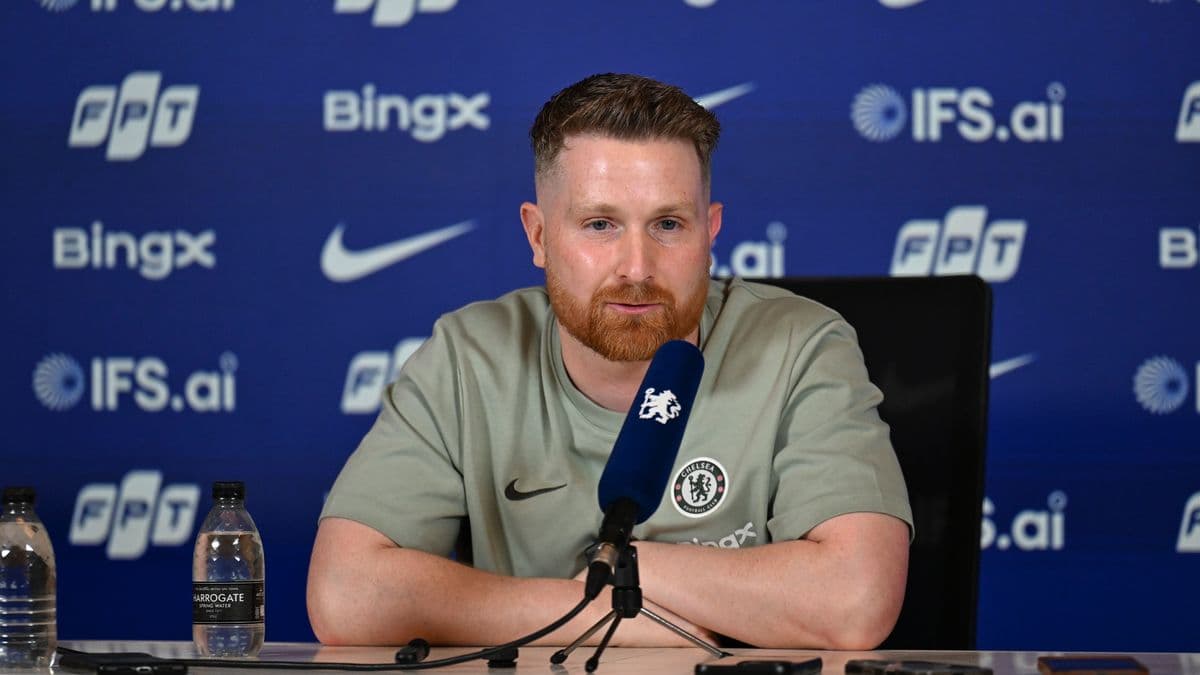 Manager at press conference with branded backdrop