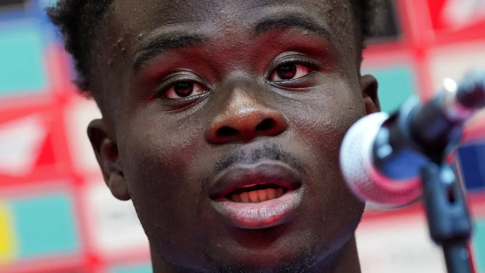 Player speaking at a press conference with microphone