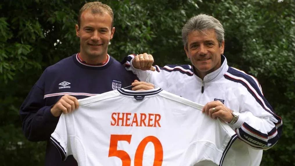 Two men holding a football shirt with 'SHEARER 50'