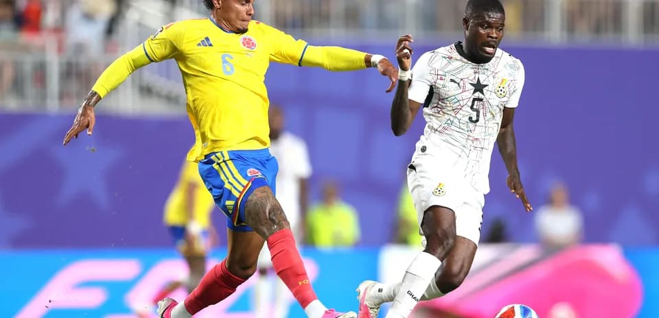 Colombia player tackling Ghana opponent during match
